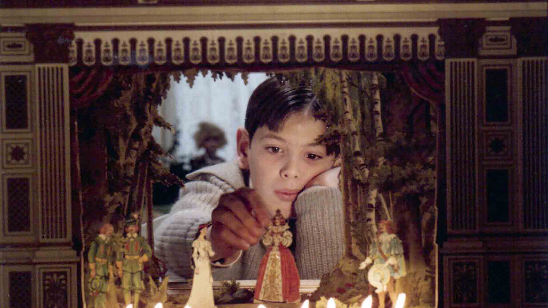 A child playing with a sculpture in the movie Fanny and Alexander