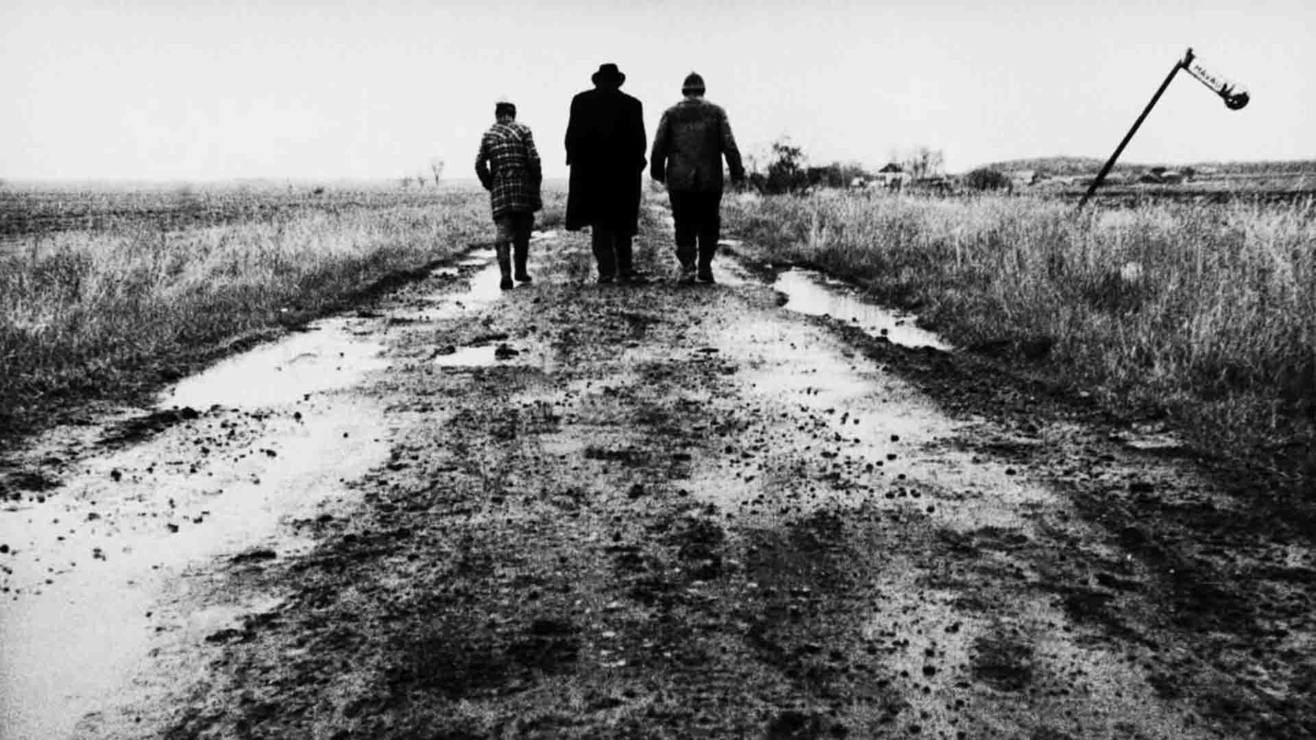 Several people walking in the mud in the movie Sátántangó