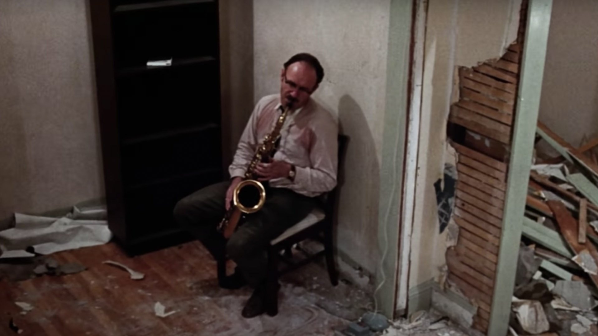Ginny Hackman sits in the rubble with a saxophone in The Conversation