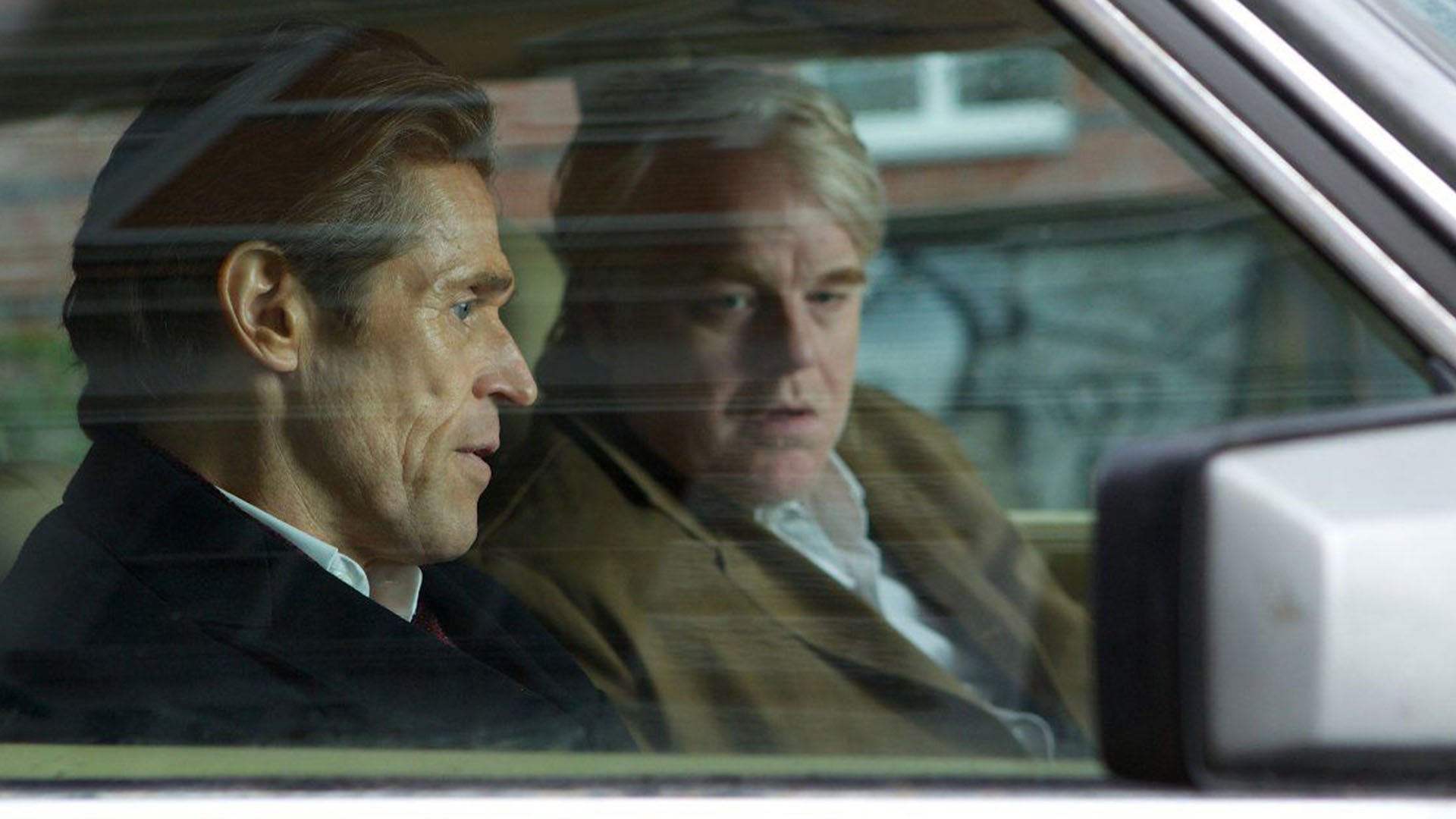Philip Seymour Hoffman sits in a car with Willem Dafoe in A Most Wanted Man