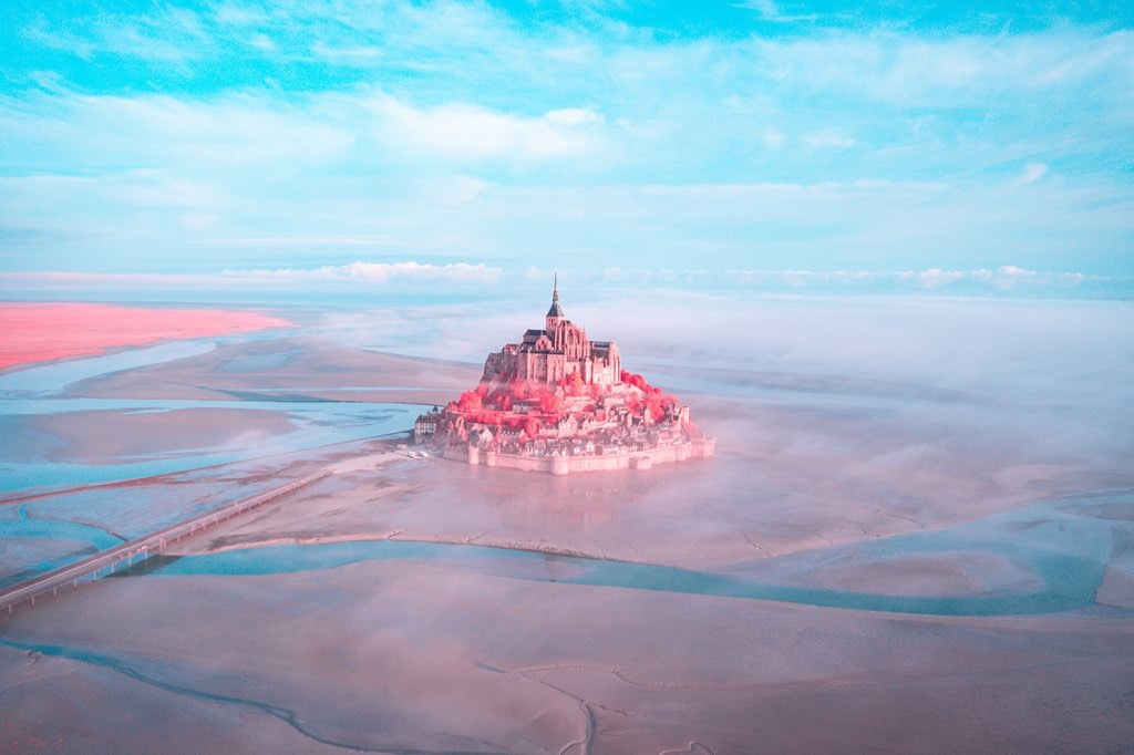 French landscapes - pink castle between water and cloudy sky