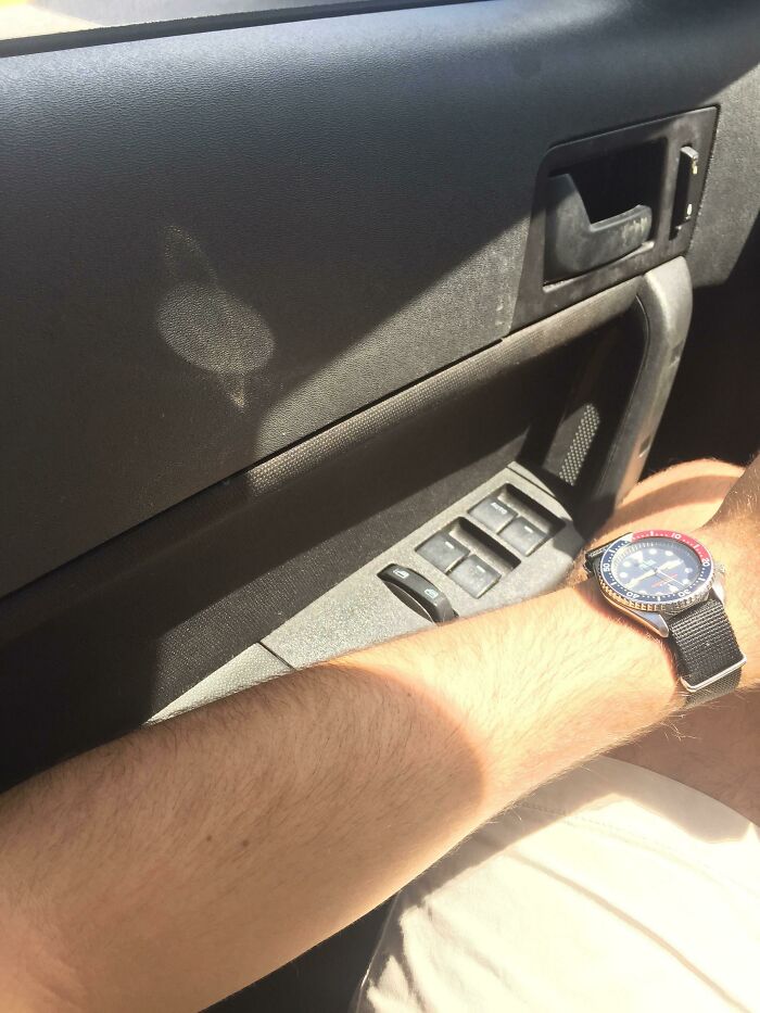 The reflection of the clock on the car door