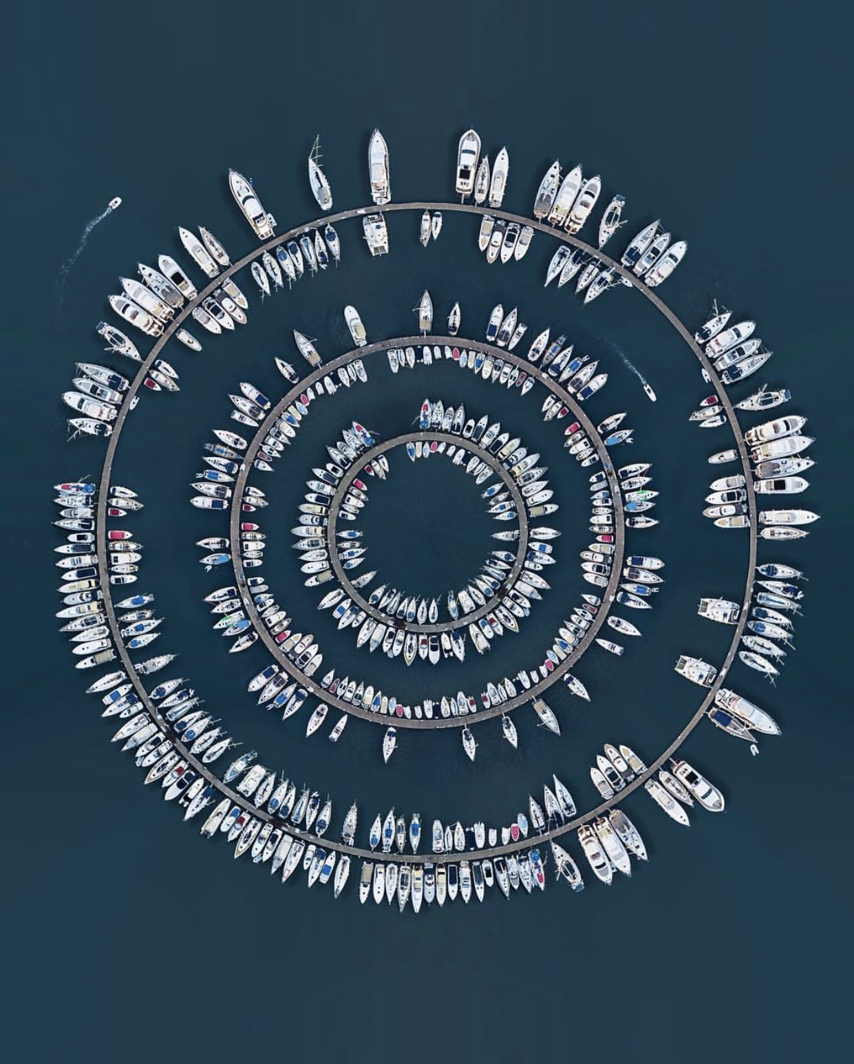 Costas Spatis took this photo with a Mavic Pro, and its settings were sensitivity set to 100, shutter speed set to 350, and aperture 0.4. The main shot was a straight row of ships on a calm Greek coast. To create this effect, Spotis used Photoshop's Polar Coordinates tool and made it look like this. Most of his works are about the sea and he is very interested in symmetry.